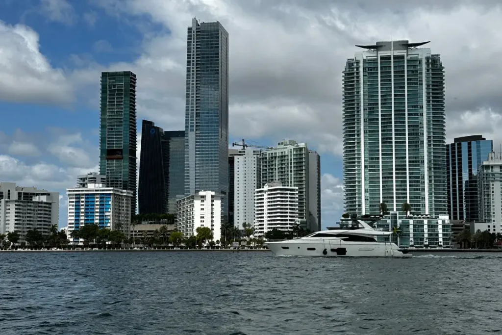 Modern waterfront skyscrapers and yacht illustrating condotel financing opportunities in Miami